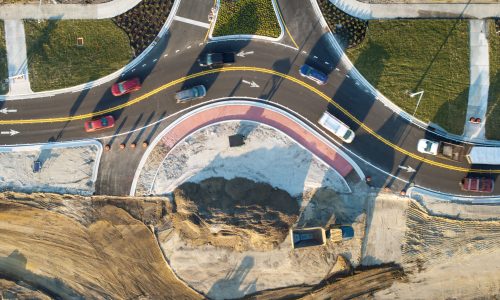 Roundabout intersection construction in North Port, Florida. Development of American road circle with moving traffic cars. Urban circular transportation crossroads.